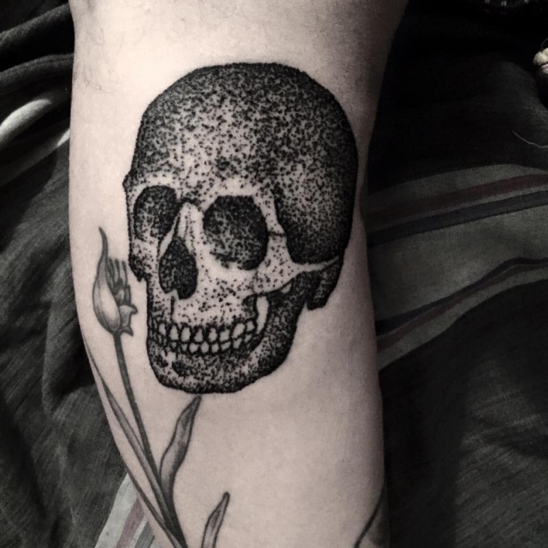 Stippling style black ink leg tattoo of human skull and flowers