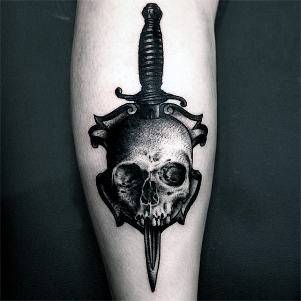 Stippling style black ink leg tattoo of human skull with dagger