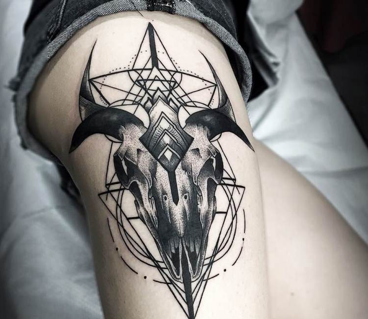 Stippling style black ink thigh tattoo of creepy skull