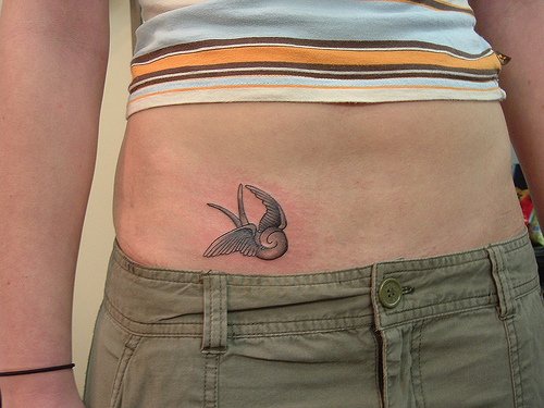Le tatouage de l&quotestomac avec un oiseau marron volent de rêve
