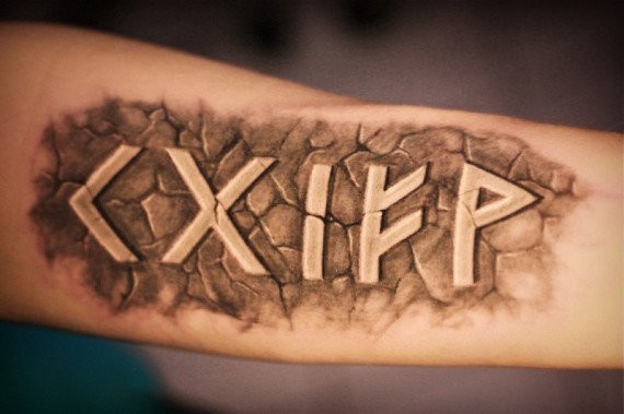 Stone like black ink arm tattoo of ancient lettering