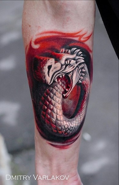 Stonework style colored forearm tattoo of dragon statue