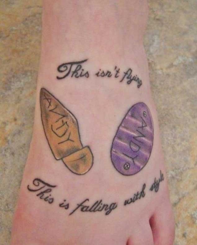 Strange designed colored little emblems tattoo on foot stylized with lettering
