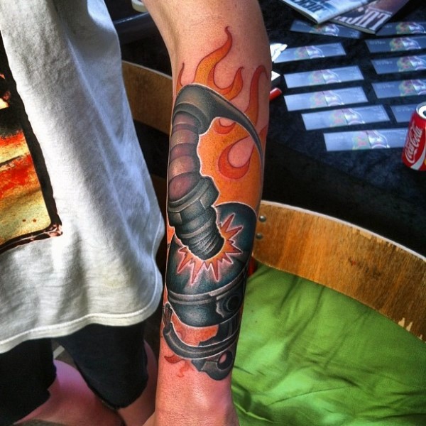 Strange looking colored forearm tattoo of car piston