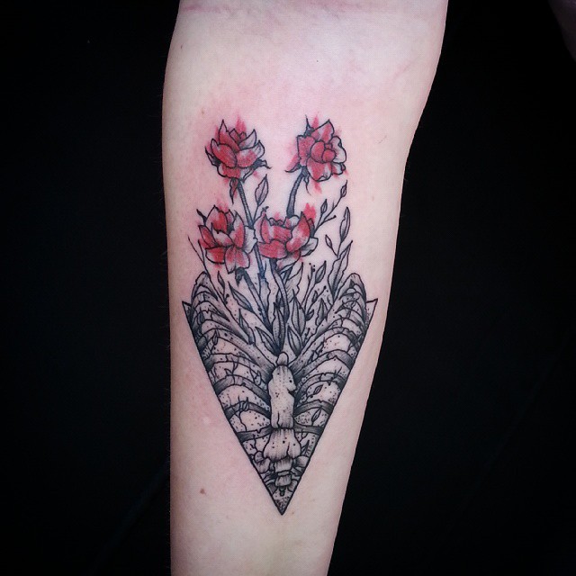 Seltsames Aquarell Unterarm Tattoo von wilden Blumen, die aus menschlichen Knochen wachsen