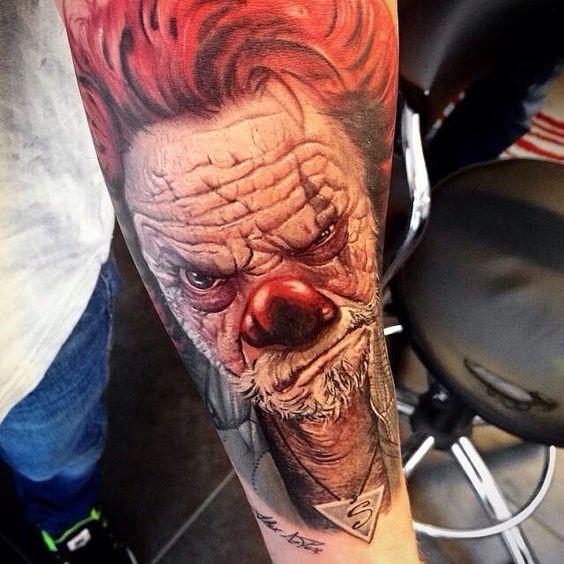 Stunning 3D detailed and colored forearm tattoo of old corrupted clown