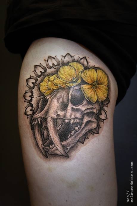Stunning 3D like colored ancient animal skull tattoo with yellow flowers