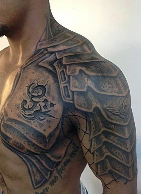 Stunning black ink armor like detailed tattoo on chest and shoulder with lettering