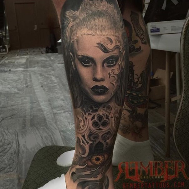 Stunning black ink leg tattoo of demonic woman with eye and ornaments