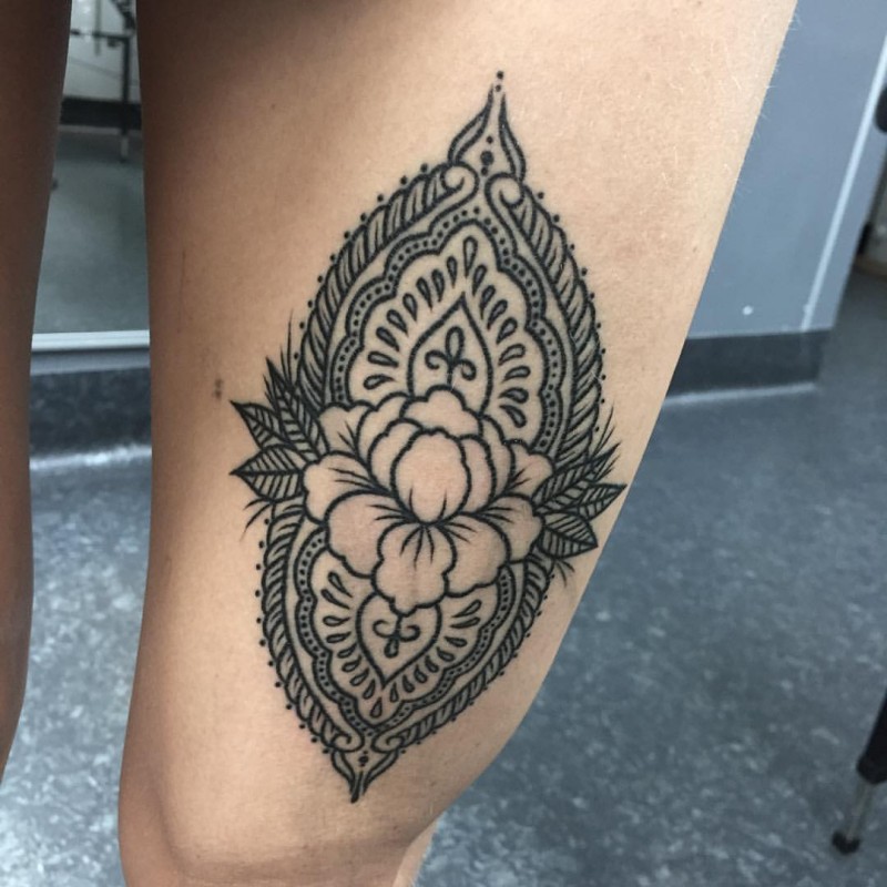 Stunning black ink thigh tattoo of Hinduism style ornament
