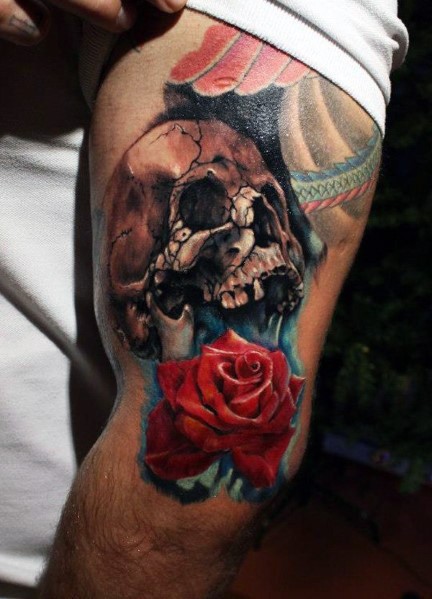 Tatuaje en el brazo, cráneo viejo agrietado con rosa linda