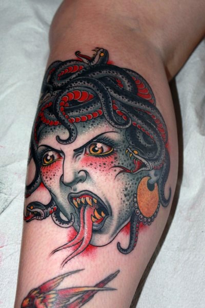 Tatuaje en la pierna, cabeza de Medusa tremenda de colores
