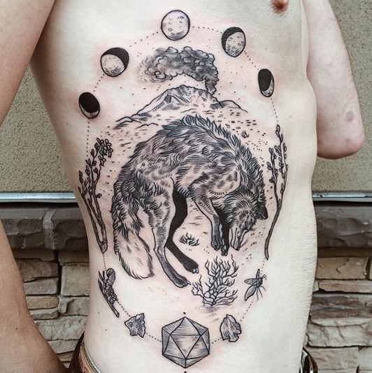 Stunning looking black ink side tattoo of sleeping fox, moon cycle and volcano