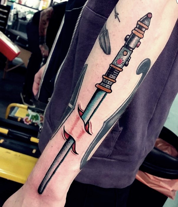 Stunning old cartoon style colored under skin lightsaber tattoo on forearm