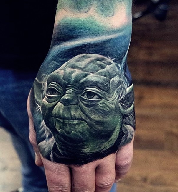 Stunning very detailed natural looking hand tattoo of master Yoda