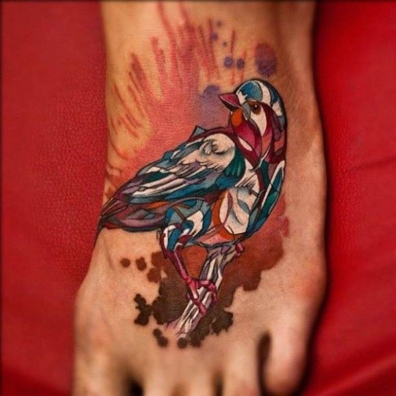Erstaunliches Tattoo vom Vogel in Watercolor -Technik auf dem Fuß von Denis Sivak