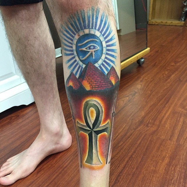 Stylish colored big leg tattoo of various symbols and pyramids