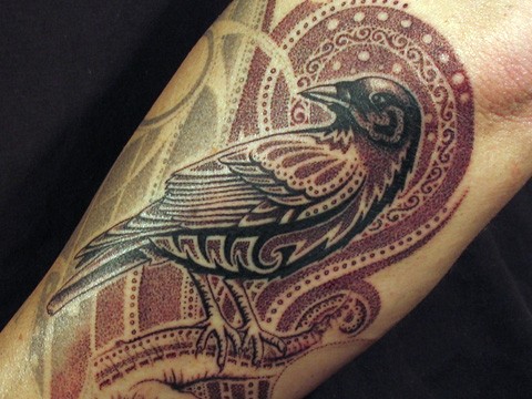 Stylized bird tattoo on arm
