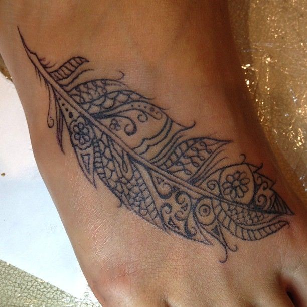 Tattoo von schön gestaltetem Feder in Tusche auf dem Fuß für Frauen