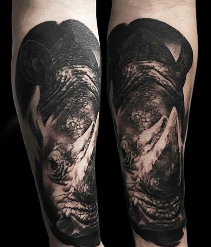 Super detailed 3D lifelike rhinoceros forearm tattoo in dark colors