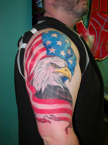 el tatuaje de hombro con una aguila sobre la bandera americana
