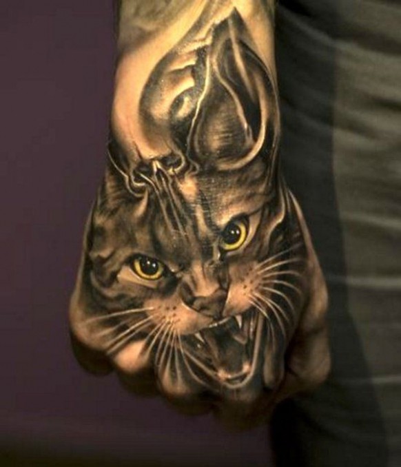 Tatuaje en la mano, gato gris con ojo amarillos