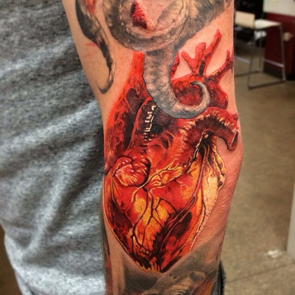 Super realistic colorful heart tattoo on arm