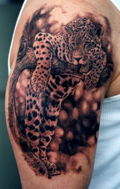 Super realistic jaguar on tree tattoo on shoulder
