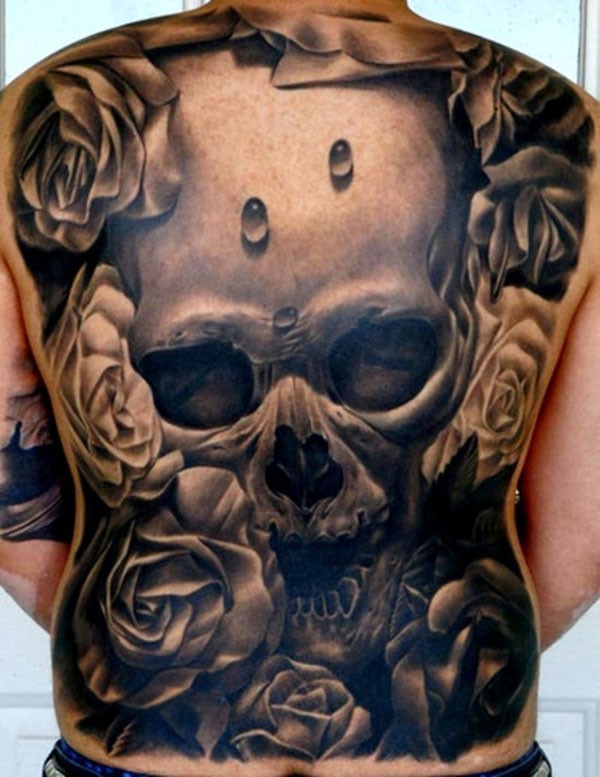 Tatuaje en la espalda, cráneo enorme entre flores