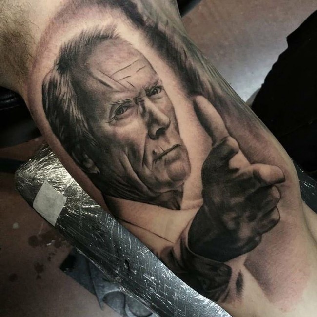 Superior black ink realistic looking old Clint Eastwood tattoo on biceps