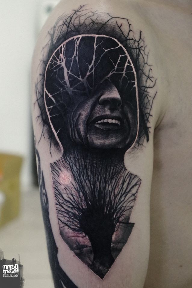 Surrealism style black ink mystical portrait tattoo on shoulder with trees