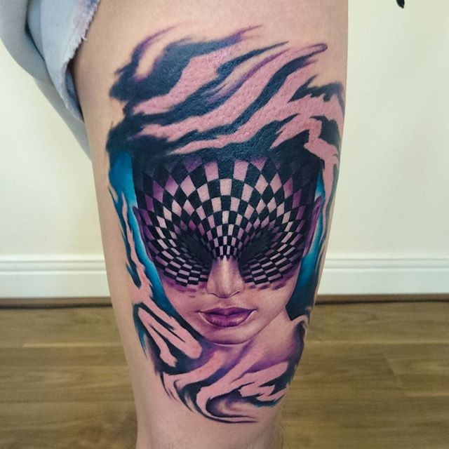 Surrealism style colored thigh tattoo of woman face with hypnotic ornament