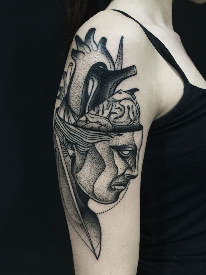 Estilo surrealista pintado por Michele Zingales tatuaje en la parte superior del brazo de la cabeza humana con corazón