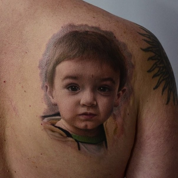 Sweet accurate painted and colored scapular tattoo of little boy portrait