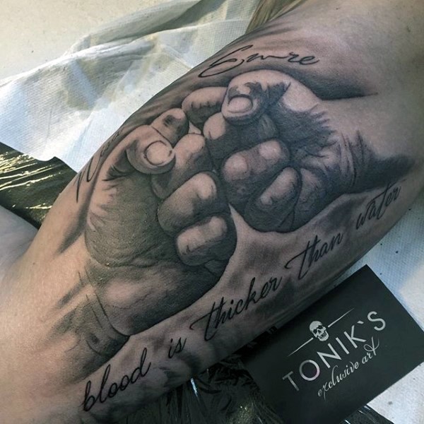 Süß gestaltete und bemalte schwarze und weiße Fäuste mit Schriftzug Tattoo am Arm