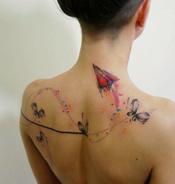 Sweet looking colored upper back tattoo of paper plane with butterflies