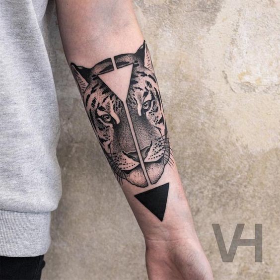 Tatuagem de antebraço de tinta preta simétrica de cabeça de tigre com triângulos por Valentin Hirsch