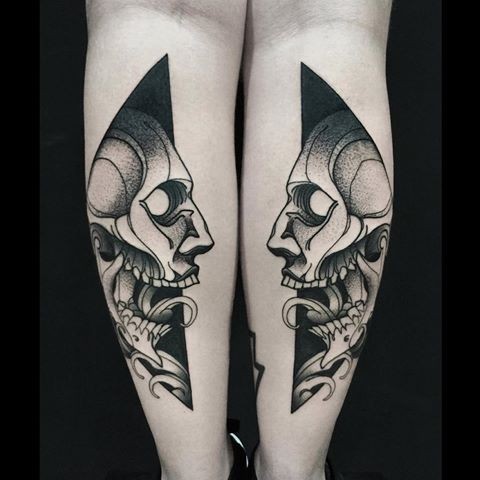 Symmetrical blackwork style painted by Michele Zingales human skulls tattoo on legs