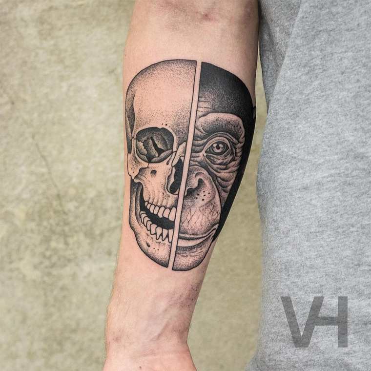 Symmetrical looking black ink forearm tattoo of human and monkey head by Valentin Hirsch