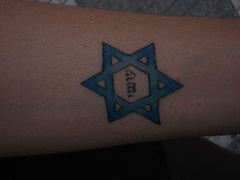 tatuaje de texto hebreo en estrella azul de david