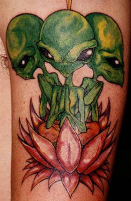 Le tatouage de trois extra-terrestres verts dans un lotus