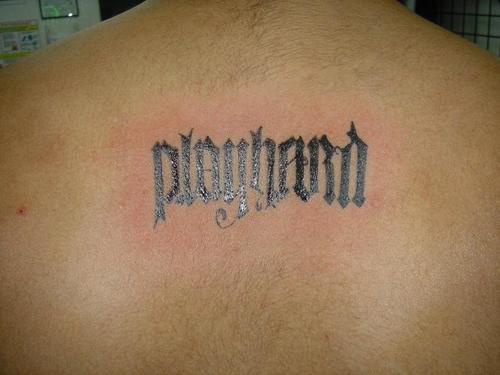 Ambigramma con la frase &quotPLAY HARD" tatuato