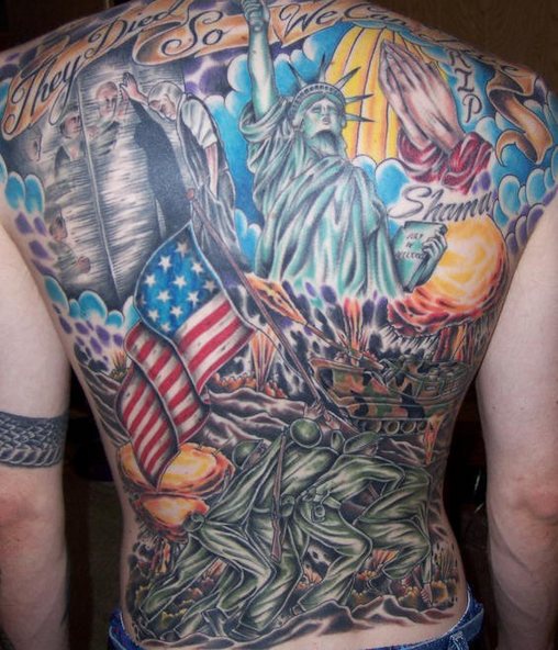 el tatuaje grande a toda la espalda de tema patriota con la estatua de la libertad, la bandera americana, soldados y manos orantes hecho en muchos colores