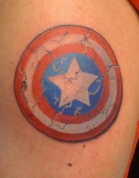 el tatuaje de escudo de capitan america con estrella en el centro hecho en color azul y rojo
