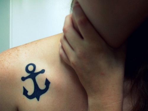 Black anchor tattoo on collarbone