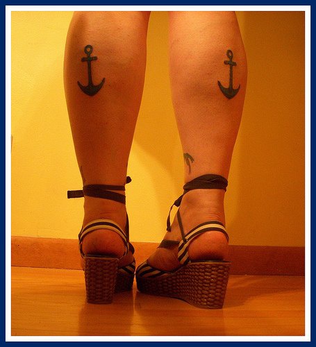 Lady anchor tattoos on both legs