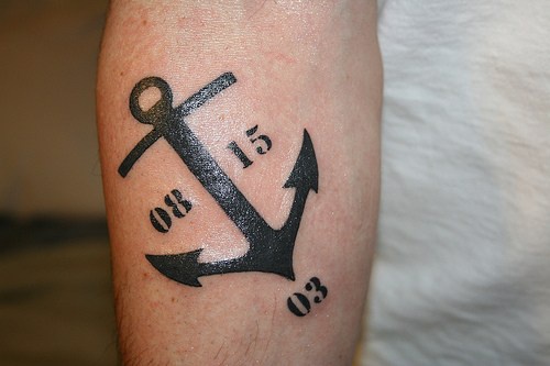 Tatouage d&quotancre marine sur le bras avec des marques de temps