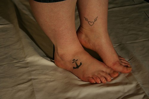 Kleine weibliche Tattoo mit Anker an Füßen