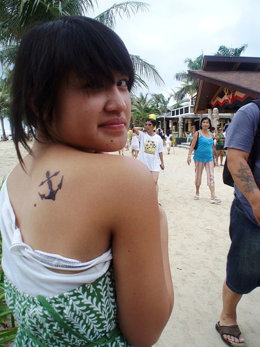 Semplice ancora tatuata sulla schiena della ragazza