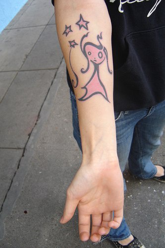 Tatuaje en el brazo Hada de color rosa con estrellas